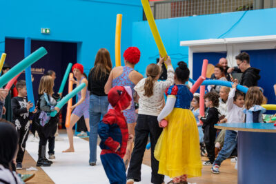 photo où les danseurs et le public se battent avec des frites en mousse de piscines - Agrandir l'image 12 sur 12, fenêtre modale